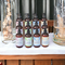 Twelve bottles of high-end lotions by Whole Self Aromatherapy atop a soft white table linen with elegant wedding decorations on either side.
